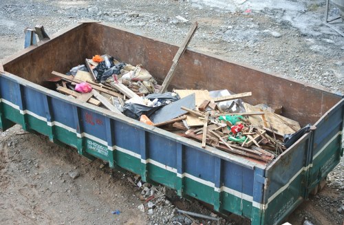 Commercial skip being loaded with construction debris